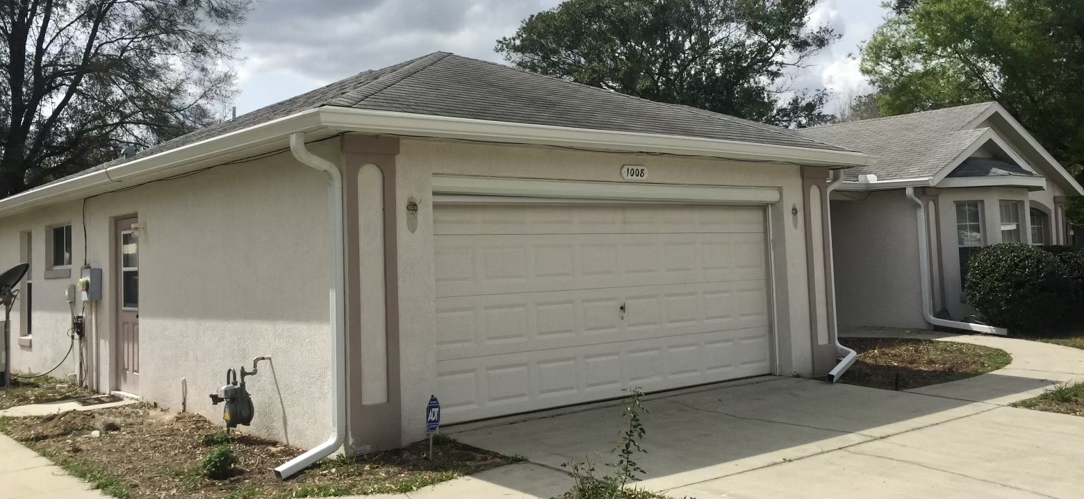 Single-story home with new white seamless gutters and downspouts
