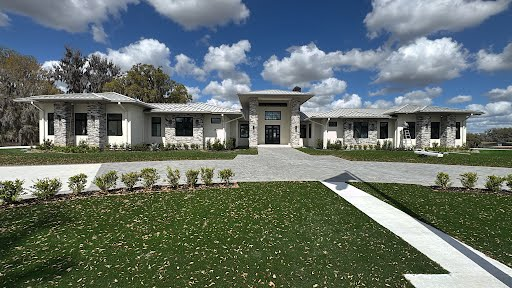 Estate home with seamless gutters and landscaping